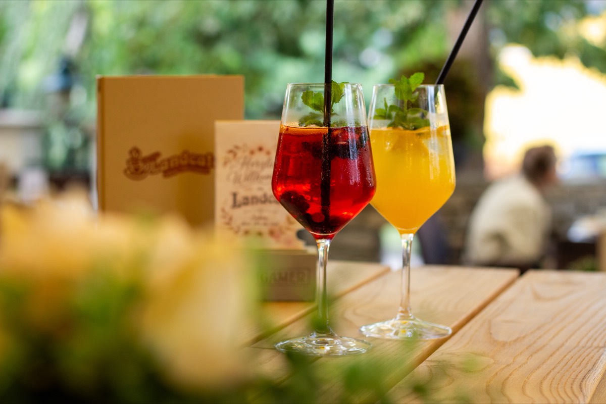 Zwei kühle Spritzer mit Minze auf einem Holztisch im Gastgarten