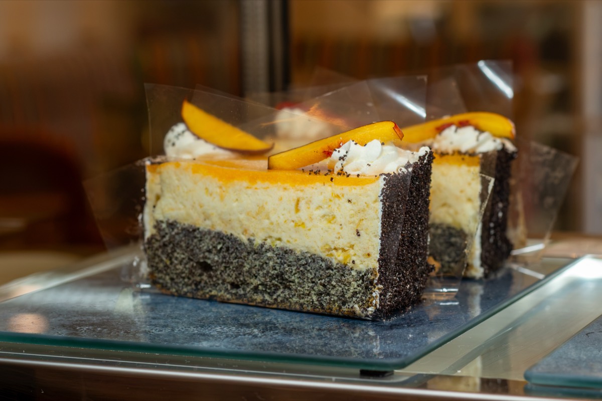 Zwei Stücke Mohn-Marillen-Torte mit Sahnehaube in der Kuchenvitrine